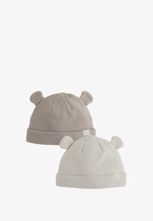 To strikkede huer: en beige og en cremefarvet. Begge har en ribbet struktur med bamseøre-detaljer og et lille påsyet mærke foran.
