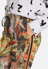 Multikleurige broek met een botanisch en dierenprint, gemaakt van een textuurstof. Inclusief een elastische tailleband en zijstrepen.