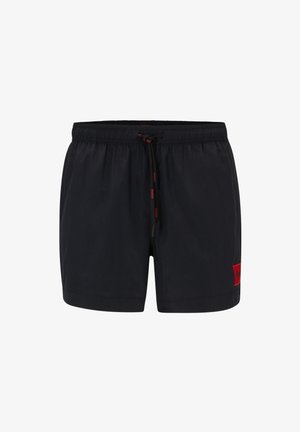 Shorts de bain noirs en tissu léger. Dotés d'une taille élastique avec cordon de serrage et d'un patch de logo rouge sur la jambe gauche.