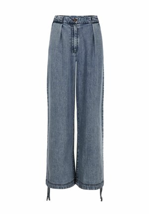 Világoskék farmervászonból készült bőszárú nadrág. Elöl ráncolt részletekkel, gombos záródással és megkötős szegéllyel rendelkezik. Simaságát jól látható varrások teszik hangsúlyossá.