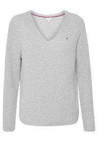 Pull tricoté gris clair avec col en V, manches longues et texture côtelée. Présente un logo discret sur la poitrine et un bord de col contrastant.