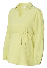 Camicia a maniche lunghe con colletto di colore giallo chiaro, caratterizzata da un tessuto testurizzato, un cinturino in vita e bottoni decorativi sulle maniche.