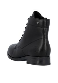 Bottines en cuir noir avec un bout rond, un laçage sur le devant et un petit talon. Présente des coutures minimalistes et un logo circulaire sur le côté.