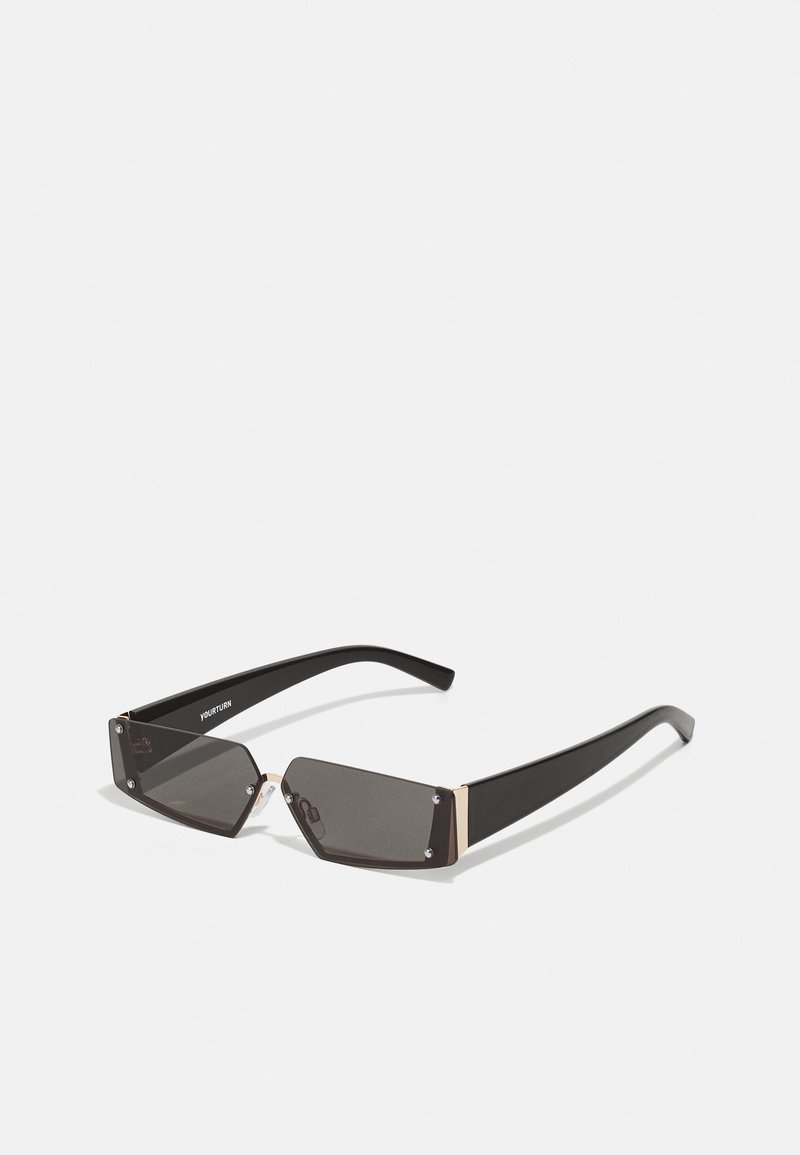 Schwarze rechteckige Sonnenbrille mit dunklen Gläsern, metallischen Akzenten an den Ecken und schlanken schwarzen Bügeln. Minimalistisches Design ohne Muster.