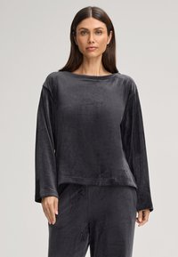 Grijze langesleeve top van zacht, glad materiaal met een ontspannen pasvorm en brede halslijn. Kenmerkt een minimalistisch ontwerp en subtiele merkaanduiding.
