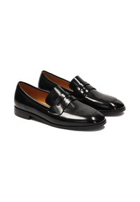 Black leather loafers with a smooth, shiny finish, featuring a decorative stitched pattern and a low heel. Brown interior lining.