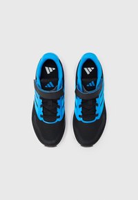 Μαύρα αθλητικά παπούτσια με μπλε και γκρι λεπτομέρειες, που διαθέτουν πλέγμα στην επάνω ε πιφάνεια, επίπεδες κορδόνια και ιμάντα βέλκρο στο μέσο του ποδιού.