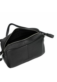 Borsa a tracolla nera in pelle con finitura testurizzata, chiusura con zip superiore e tracolla regolabile. L'interno è foderato in tessuto nero.