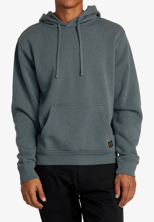Sudadera con capucha en verde azulado apagado, hecha de un tejido suave. Cuenta con un bolsillo frontal y puños y dobladillo acanalados. Acentuada con un parche de logo.
