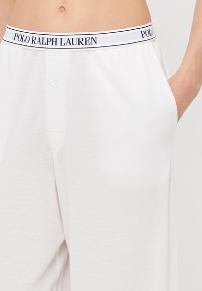 Pantaloni albi cu o textură netedă, având un sistem de închidere cu nasturi, buzunare laterale și un tiv cu logo-ul și dungi în nuanță navy "POLO RALPH LAUREN".