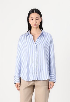 Light blue and white striped button-up shirt with long sleeves, collar, and oversized fit, made from a smooth fabric.