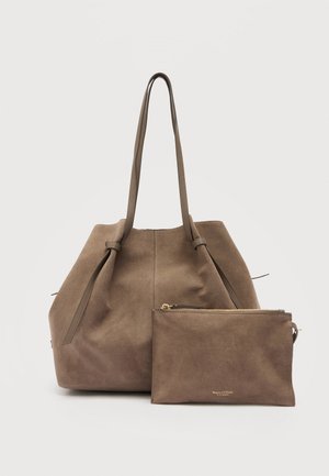 Grand sac cabas en daim marron avec de longues poignées et une pochette assortie à fermeture éclair placée devant sur un fond clair uni.