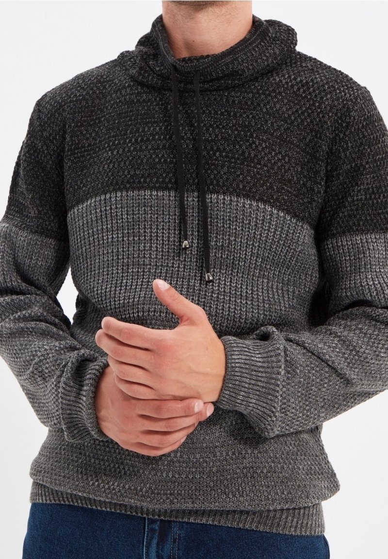 Gebreide pullover in zwart en grijs, met een hoge kraag, koordje en getextureerde patronen. Comfortabele pasvorm met geribde cuffs en zoom.