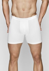 White boxer briefs made from soft fabric, featuring a snug elastic waistband and a seamless design. No patterns or logos are visible.