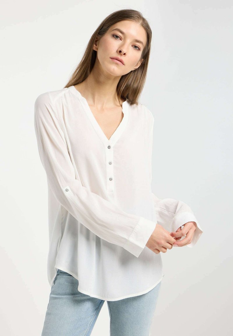 Blusa bianca a maniche lunghe con scollatura a V, dotata di un bottone e dettagli sui polsini, realizzata in tessuto leggero; texture liscia e vestibilità morbida.