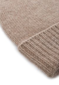 Bonnet en tricot marron fabriqué en fibre douce. Il présente un revers côtelé en bas et une surface texturée, soulignant sa chaleur et son confort.