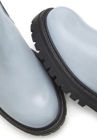 Helleblaue Leder-Ankle-Boots mit dicken schwarzen Gummisohlen, abgerundeten Spitzen und glatter Textur, ausgestattet mit einem minimalistischen Design.