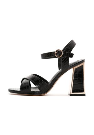 Black high-heeled sandal with crocodile texture, featuring a round metal buckle and a geometric gold-accented block heel.