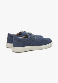 Chaussures en daim bleu avec une texture lisse, dotées d'un bout arrondi, de surjet ton sur ton, et de semelles en caoutchouc légères. Design simple à lacets.