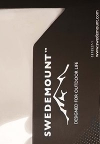 Asennustarvike valko-mustalla designilla, jossa tekstit "SWEDEMOUNT™" ja "DESIGNED FOR OUTDOOR LIFE" sekä teksturoitu pistekuvio.