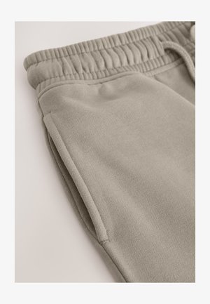 Gaiši pelēkas bikses no mīksta auduma ar elastīgu jostu, sānu kabatām un ikdienišķu dizainu. Gluda faktūra visā garumā.