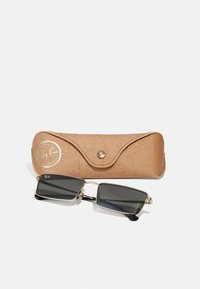 Ray-Ban'i prillid mustade läätsedega, millel on ristkülikukujuline kuju, koos tan värvi, tekstureeritud nahkkotikese ja kuldse märgisega klõpsuga.