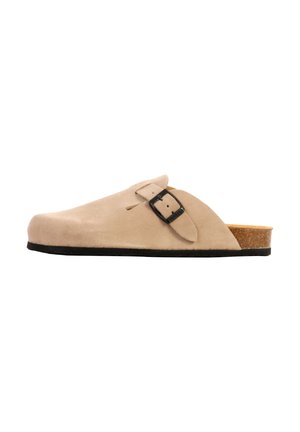 Beige ruskind slip-on træsko med sort spænde, korkfodseng og sort sål, vist fra ydersiden på hvid baggrund.