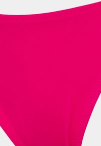 Lys rosa bikini-bunn laget av elastisk stoff. Har en glatt tekstur og rene kanter, uten ekstra mønstre eller dekorasjoner.