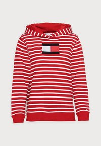 Felpa a righe rosse e bianche con tasca frontale, dotata di un logo rettangolare in blu navale, rosso e bianco. Materiale in cotone morbido, maniche lunghe.