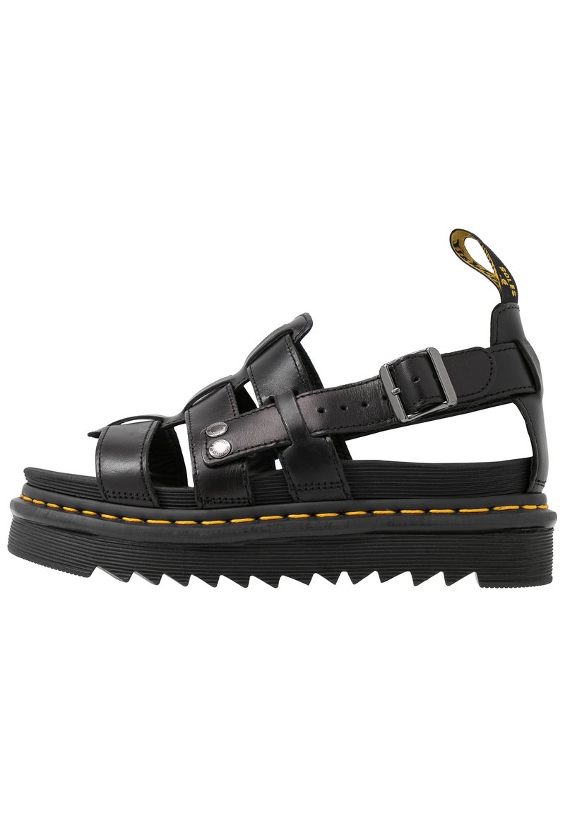 Sandalias de cuero negro con múltiples tiras, hebilla ajustable, suela gruesa en zigzag y detalle de costura amarilla a lo largo del borde.