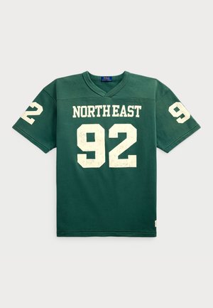 Camiseta de algodón verde con mangas cortas, que presenta "NORTHEAST" y el número "92" en texto blanco desgastado en la parte delantera. Diseño de escote en V.