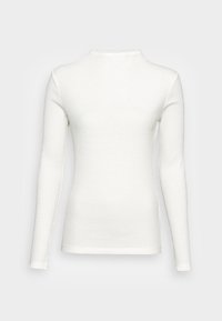 Bílý dlouhý rukáv ribbed top s vysokým výstřihem, s tvarovaným střihem a surovými okraji na manžetách a spodním lemu.