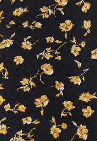 Tissu noir avec un petit motif floral jaune et blanc réparti uniformément sur toute la surface.