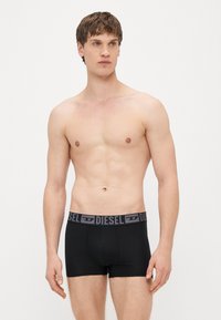 Mustad puuvillased bokserid helehalli logoga vöökohaga. Disain on keha järgiv klassikalise lõike, sileda tekstuuri ja ilma lisamustriteta.