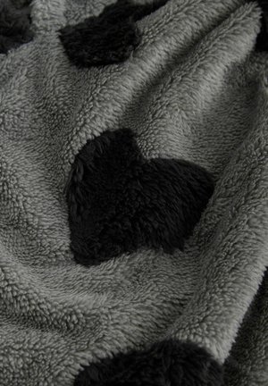Pătură gri din fleece cu modele de inimă negre în relief, având o suprafață moale, texturată și un luciu subtil.
