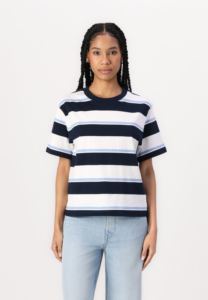 Cotton t-shirt featuring horizontal stripes in navy, light blue, and white, with a round neck and short sleeves, paired with light jeans.