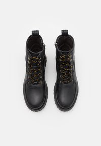 Black leather ankle boots with round toes, textured surfaces, gold and black laces, and pull tabs on the heel for easy wear.