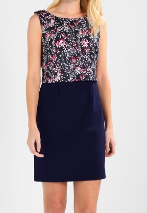 Robe sans manches avec un haut à imprimé floral en marine, rose et blanc, accompagné d'une jupe unie marine ; tissu lisse et design ajusté.
