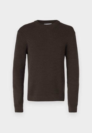 Mörkbrun tröja med en texturerad, ribbad design. Rund halsringning och långa ärmar, med åtsittande manschetter och rak nederkant.