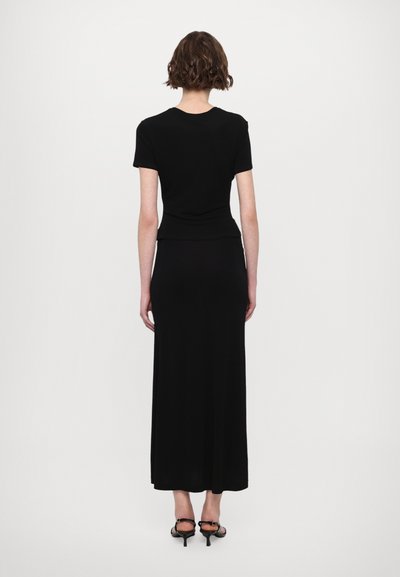 Black, form-fitting short-sleeve top with a high neckline, paired with a long black skirt. Smooth texture, minimal design, and no visible patterns.
