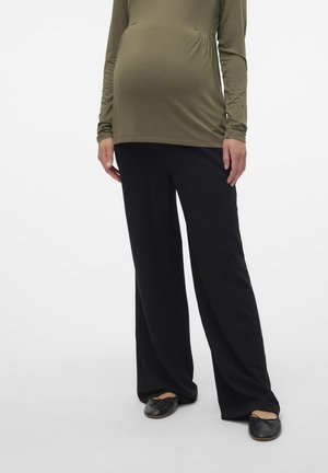 Maternity top in olive green, long sleeves, gathered at the waist, paired with black wide-leg pants. Footwear: black slip-on shoes.