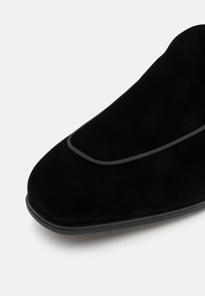 Schwarzer Wildlederschuh mit einer glatten Oberfläche, spitzer Zehenpartie und kontrastierender grauer Naht entlang der Naht. Gummisohle sorgt für Stabilität.