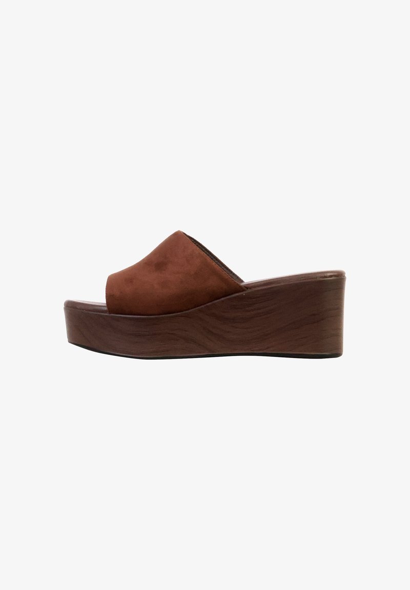 Sandale mule en daim marron à bout ouvert avec talon compensé épais en bois sur fond blanc.