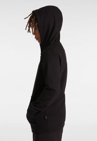 Svart hoodies med mjukt tyg. Har en känguruficka, ribbade ärmslut och nederkant. Avslappnad passform, slät textur och minimalistisk design.