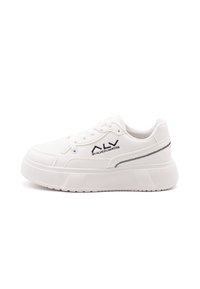 Sneaker bianco con tomaia sintetica liscia, chiusura con lacci e suola rialzata. Presenta un logo nero a contrasto e dettagli di cucitura.