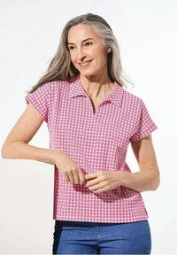Korte mouwen polo in het roze met een geometrisch patroon, voorzien van een kraag en een relaxed fit. Zacht materiaal met een gladde textuur.