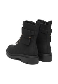 Černé kotníkové boty s matným povrchem, s bočním zipem, tkaničkovým zapínáním, zlatými detaily a silnou gumovou podrážkou.