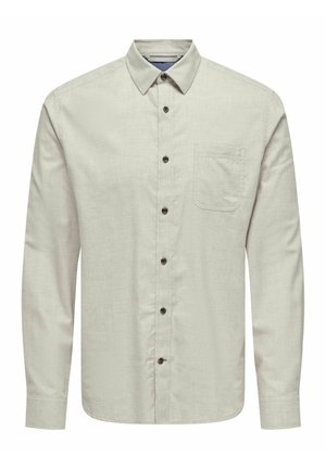 Chemise à manches longues gris clair avec un col, dotée d'une poche poitrine et de boutons foncés sur un fond en tissu texturé.