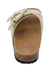 Beige wedge sandaal met kurken zool, voorzien van twee verstelbare banden met gouden hardware en doorzichtige versieringen op de banden.