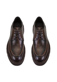 Chaussures en cuir marron avec une finition lisse, présentant un bout arrondi, cinq œillets et une semelle en caoutchouc marron épaisse. Design minimaliste.